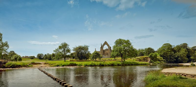 The stepping stones across the River Wharfe at Bolton Abbey, with the priory ruins beyond